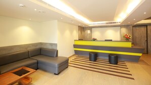 A modern reception area with a sofa, a reception desk, and a striped rug.