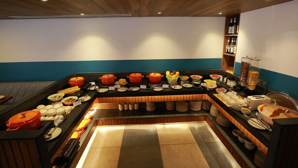 A buffet setup with various food items and utensils.