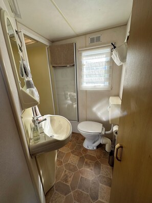 Une petite salle de bain comprenant un lavabo, des toilettes et une douche.