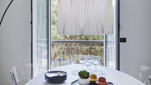 A dining table with plates, glasses, and a small plant. - Shelley Apartments - Sun by Wonderful Italy (Genova)