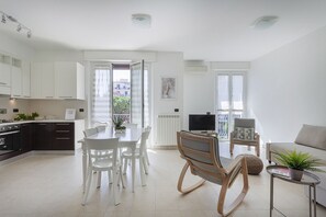 Eine moderne Wohnung mit Küche, Essbereich, Wohnzimmer und Balkon.