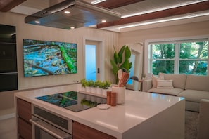 Enjoy cooking in the well-equipped kitchen with a central island, induction cooktop, and sink.