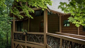 A wooden cabin with a balcony, surrounded by trees. - Nature lovers paradise in Connestee Falls 14 minutes to Brevard! (Brevard)
