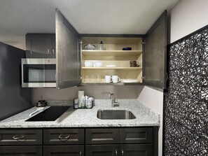 Enjoy cooking in this well-equipped kitchen with a sink, modern faucet, and ample storage.