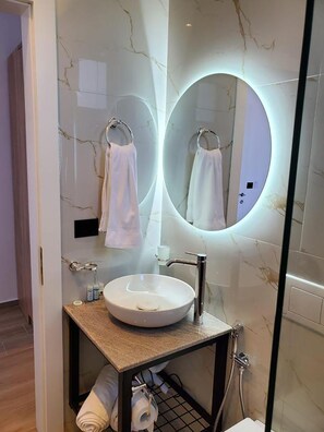 Habitación triple Deluxe, vista al mar | Baño | Secadora de cabello, bidet, toallas 