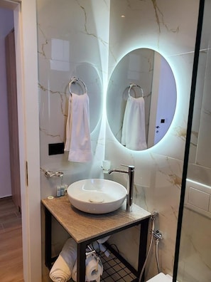 Habitación triple Deluxe, vista al mar | Baño | Secadora de cabello, bidet, toallas