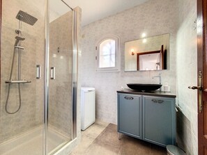 Een bad/douchecombinatie, een haardroger, handdoeken, toiletpapier