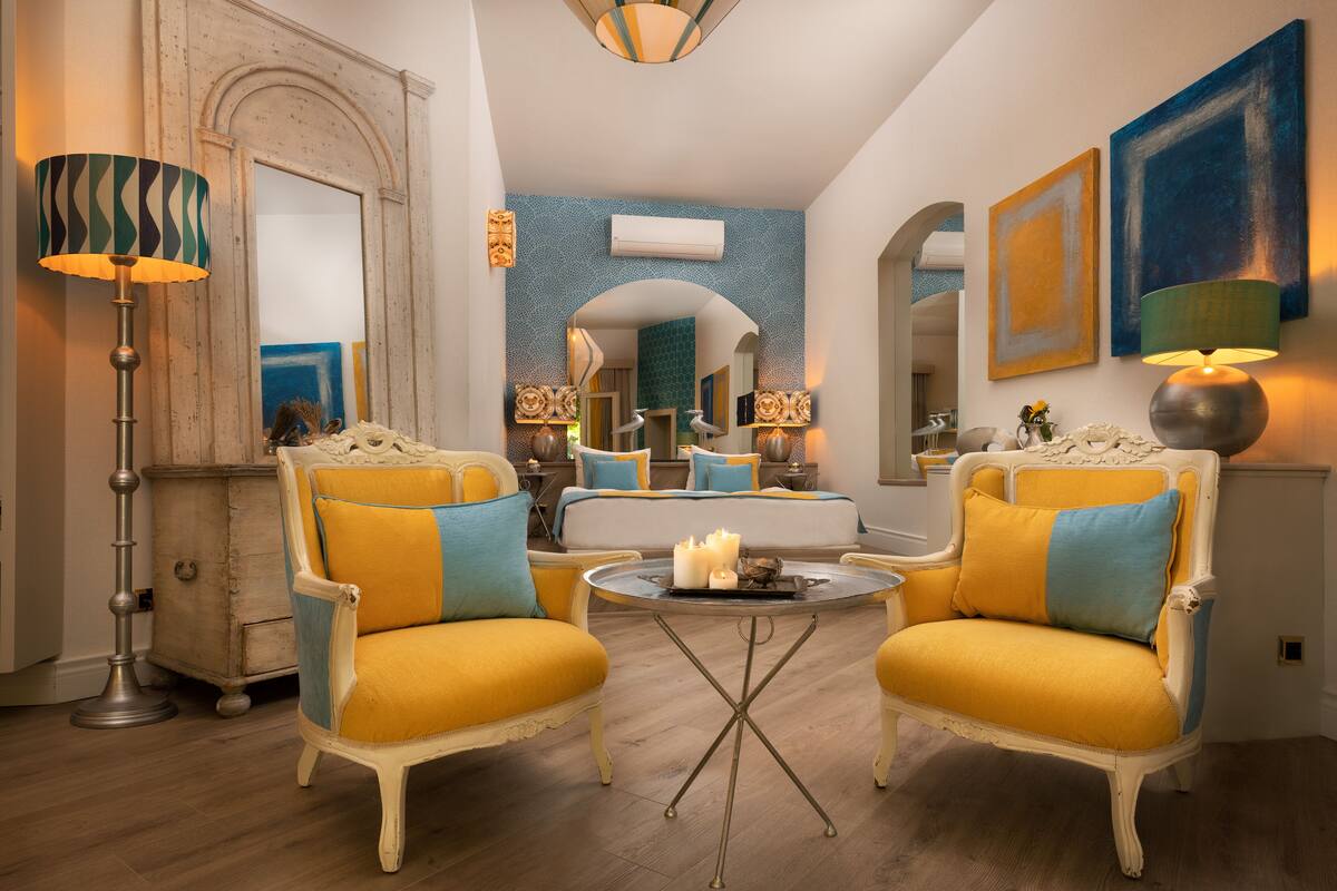 A living room with two yellow armchairs, a round coffee table, and a floor lamp.