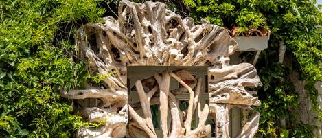 Une sculpture représentant des branches entrelacées, située dans un jardin.