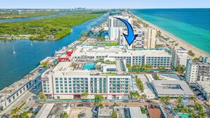 Oversigtsbillede af et kysthotel med flere bygninger, en lysthavn og en strand.