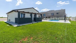 A modern two-story house with a swimming pool, a covered patio, and a well-maintained lawn. - Villa Marino with private pool (Vodnjan)