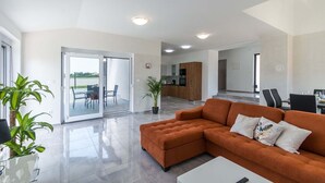 A modern living room with a sofa, a coffee table, and a dining area with chairs. - Villa Marino with private pool (Vodnjan)
