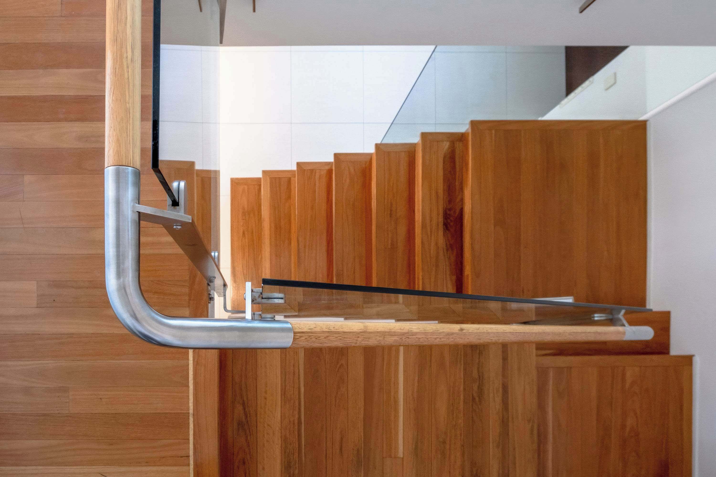A modern staircase with wooden steps and metal handrails.