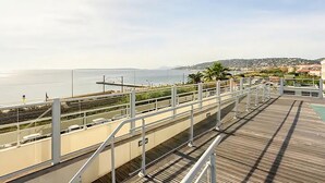 Un camino costero con vista al mar y colinas distantes.