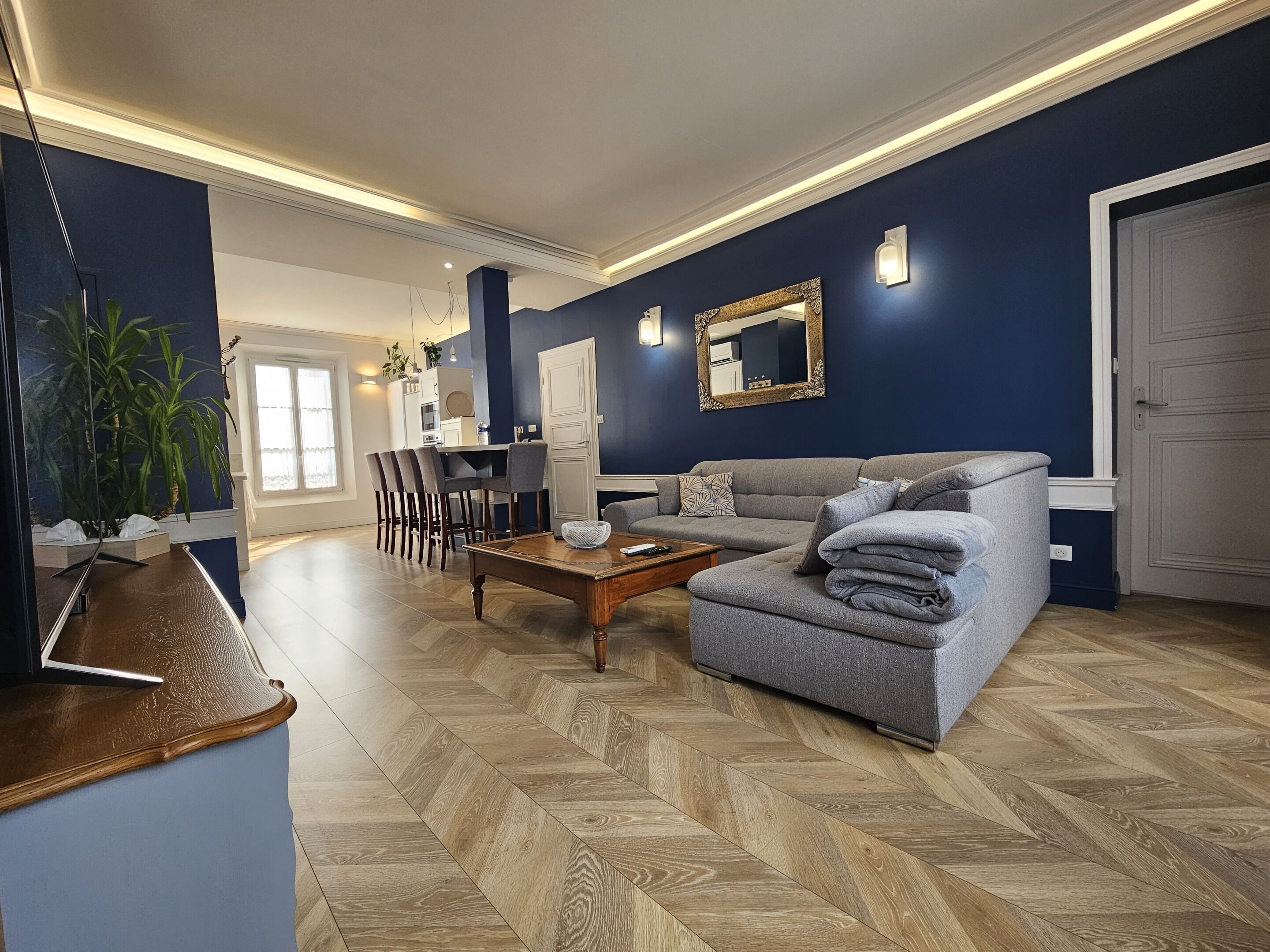 Een moderne woonkamer met een bank, salontafel en eethoek.