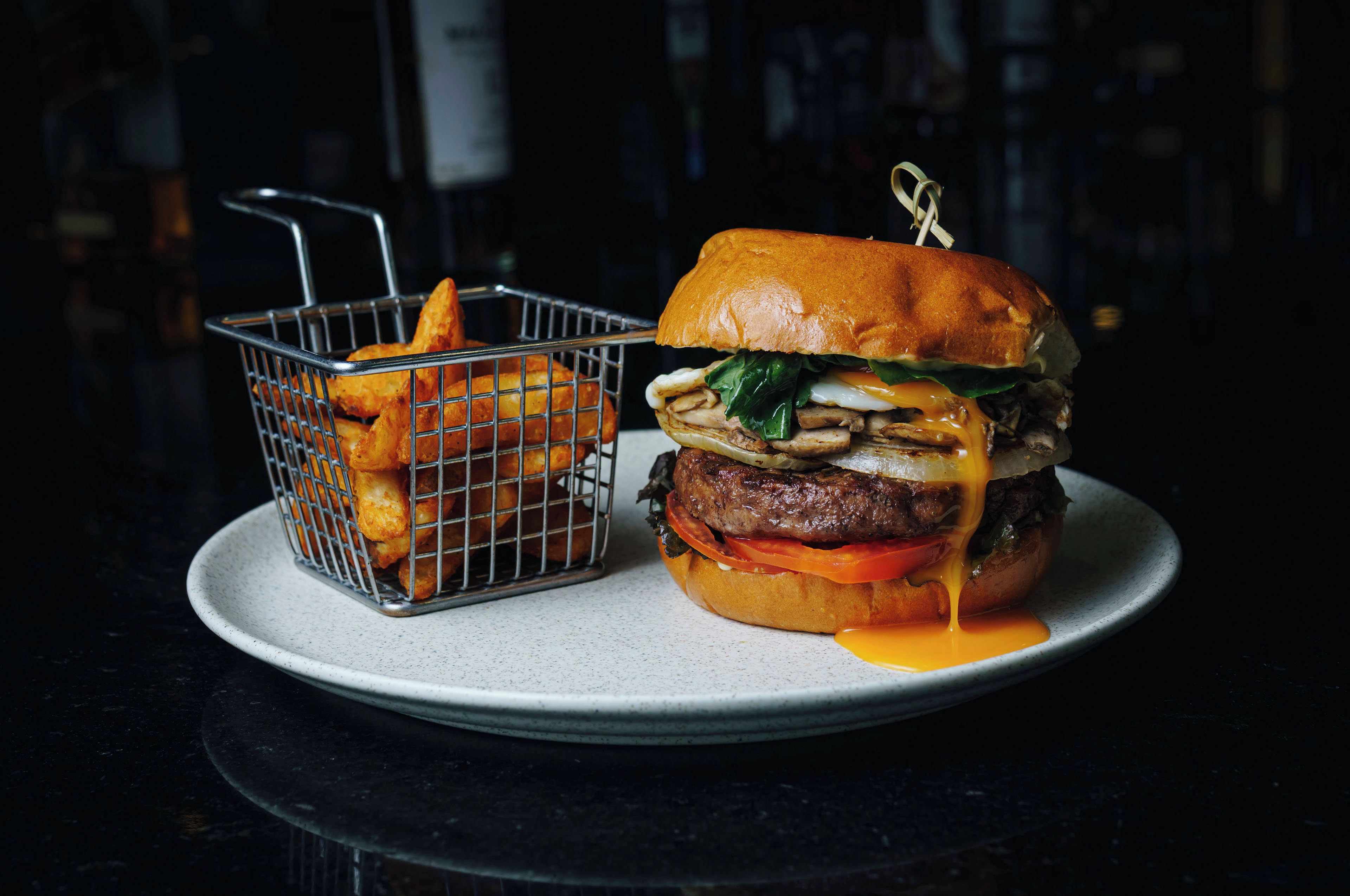Una hamburguesa con papas fritas en un plato.