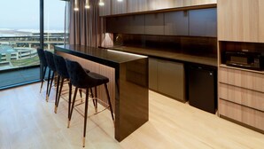 A modern kitchen with a large island, bar stools, and a view of a bridge. - Holiday Inn Hotel and Suites Mexico Felipe Angeles Airport by IHG (Zumpango)