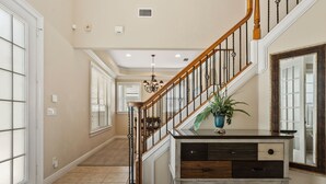 A spacious hallway with a wooden staircase, a large mirror, and a potted plant. - Homestead Laurel: Private Pool, Water Park, Golf View, Near Disney (Kissimmee)