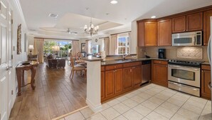 Una cocina amplia con gabinetes de madera, electrodomésticos de acero inoxidable y una isla grande.