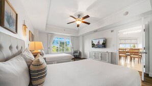 Ein Hotelzimmer mit einem großen Bett, einem Deckenventilator, einem Fernseher und Blick ins Freie.