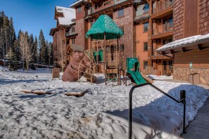 A ski resort with a wooden building, a play structure, and snow-covered ground. - Fabulous Vaulted Penthouse Condo at Grand Lodge on Peak 7 Breckenridge, CO (Breckenridge)