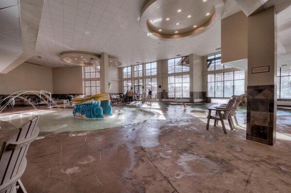 Amplio espacio interior con una gran piscina, zonas de estar y ventanas grandes que permiten la entrada de luz natural.