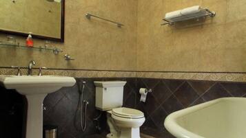 Un baño con lavamanos, inodoro y bañera.