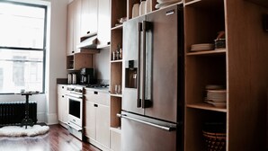 Een moderne keuken met houten kastjes, een roestvrijstalen koelkast en een inbouwoven.