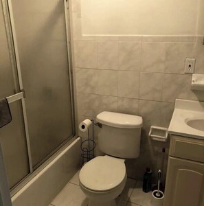 Bathroom features a toilet, shower enclosure, and sink.