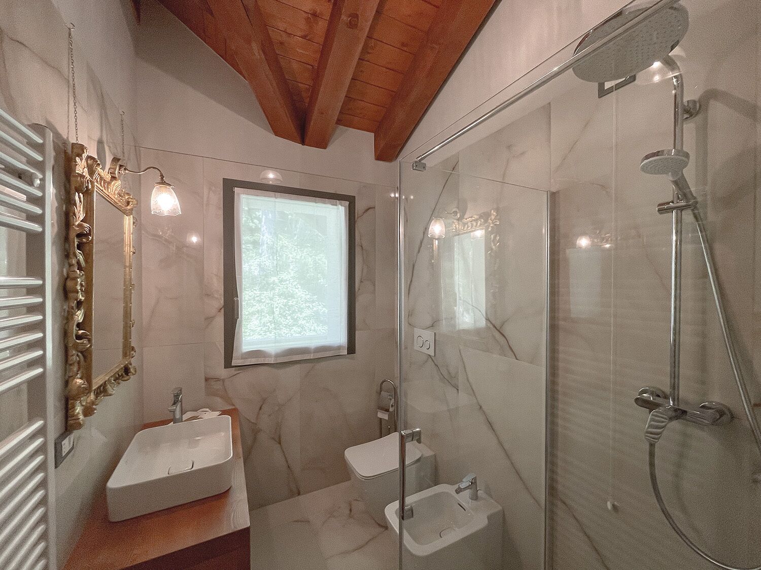 Un baño con ducha de vidrio, lavamanos y espejo.