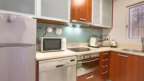 Una cocina moderna equipada con refrigerador, microondas, estufa, horno y pileta.