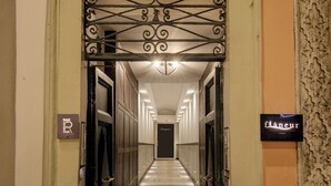 L’entrée d’un hôtel, avec un portail en métal, une enseigne indiquant « flaanur » et un panneau « P » pour indiquer le parking.