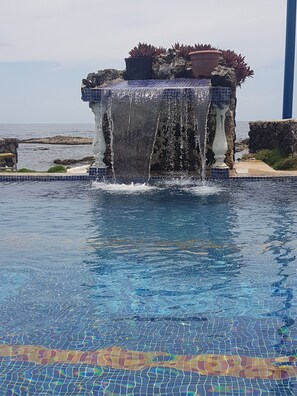 A pool with a water feature, including a fountain and plants. - Hotel La Cueva De Limón (Limón)