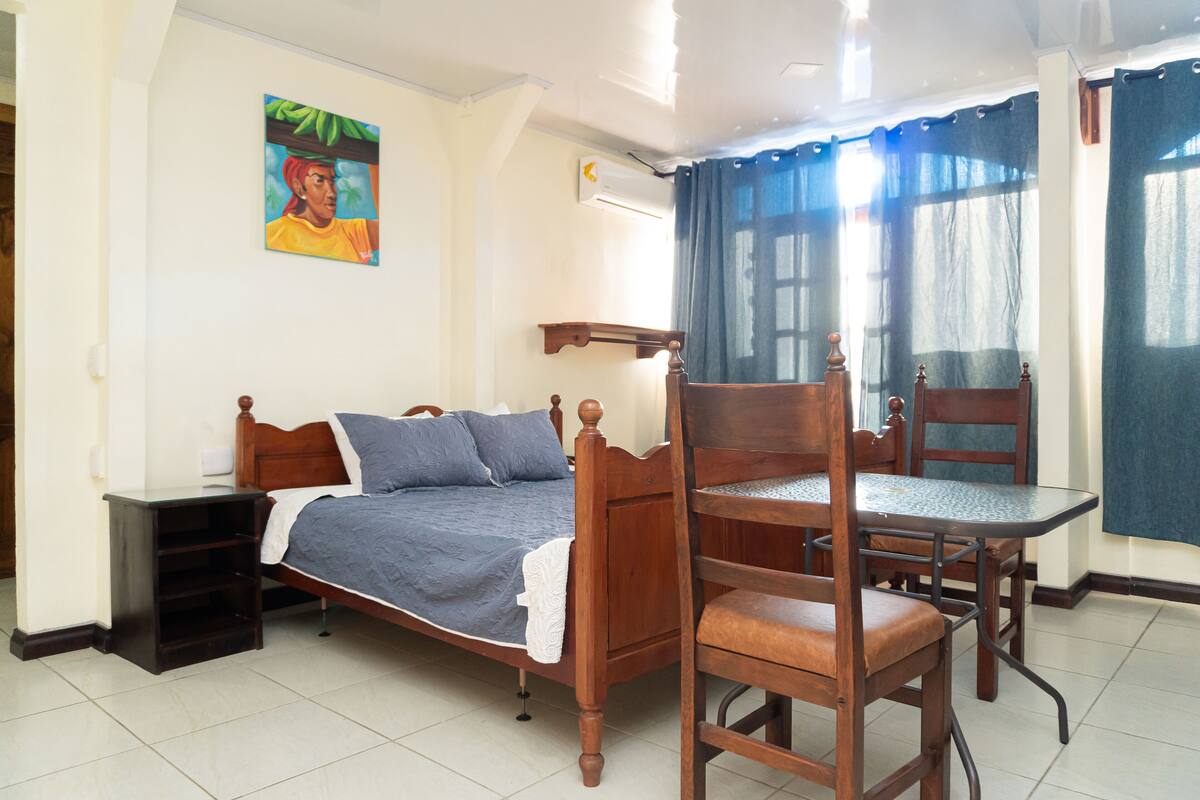 A bedroom with a wooden bed, a small table, and chairs.