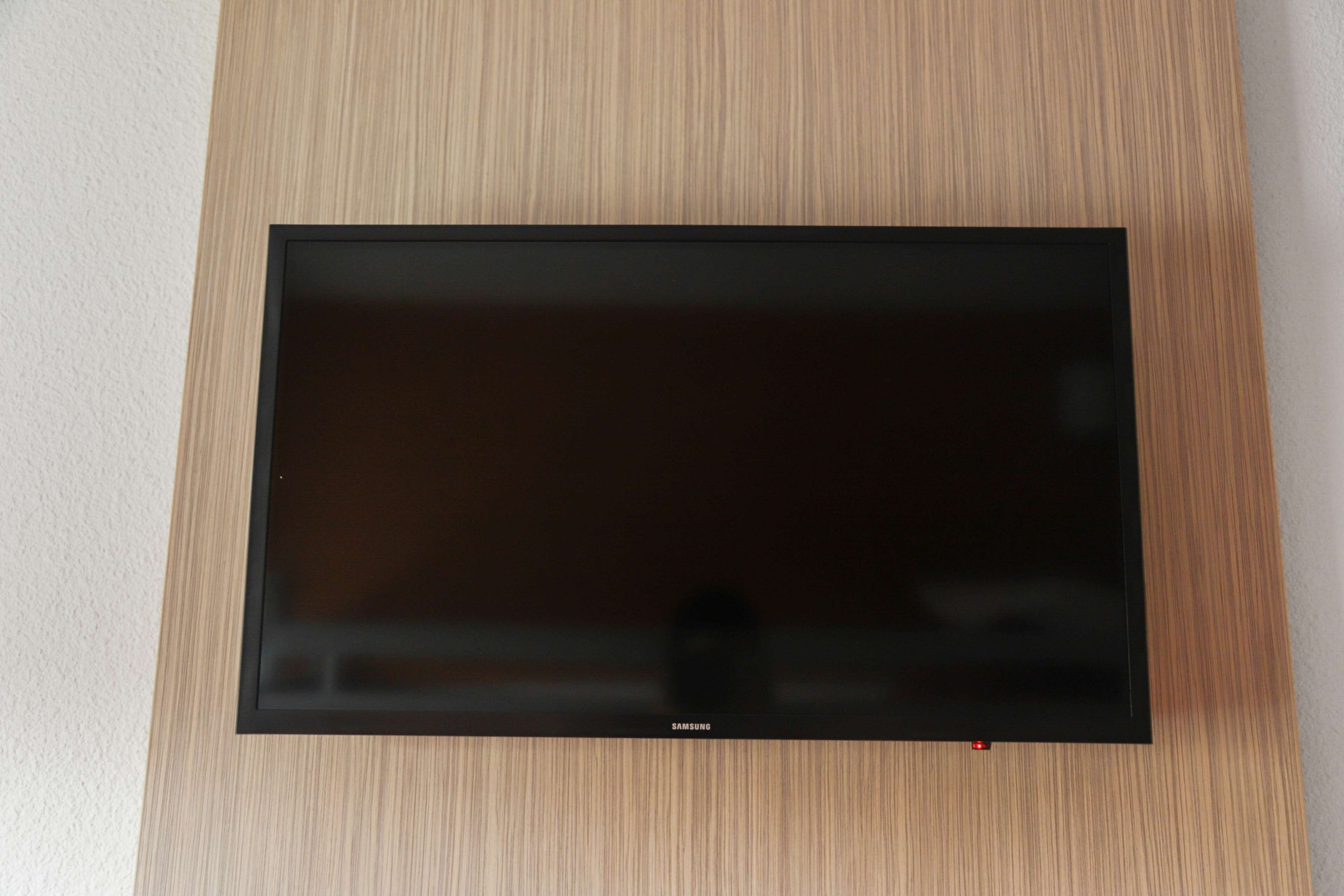 A flat-screen TV mounted on a wooden wall.