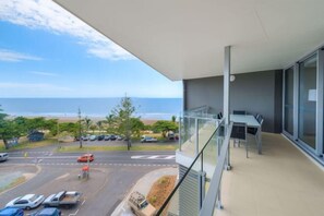 Uma varanda com vista para a praia e o oceano.