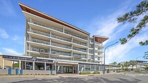 A multi-story hotel with a modern design, featuring balconies on each floor and a prominent entrance with signage for 'CRIMSON' and 'FINCH'. - Salt Yeppoon (Yeppoon)