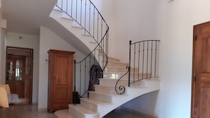 A staircase with a curved design, white steps, and black metal railings. - Villa des oliviers ideal for visiting Provence (Caumont-sur-Durance)
