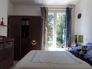 A bedroom with a bed, a wardrobe, a window with curtains, and a panda plush toy on the bed. - Villa “Des Oliviers” – perfect for a visit to Provence (Caumont-sur-Durance)