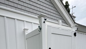 A white outdoor storage unit with a metal ladder and a wooden step. - Remodeled Jamestown beach cottage within walking distance to beach (Jamestown)