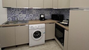 Een koffiezetapparaat/waterkoker, een koelkast, een magnetron, een oven