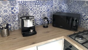 Een koffiezetapparaat/waterkoker, een koelkast, een magnetron, een oven