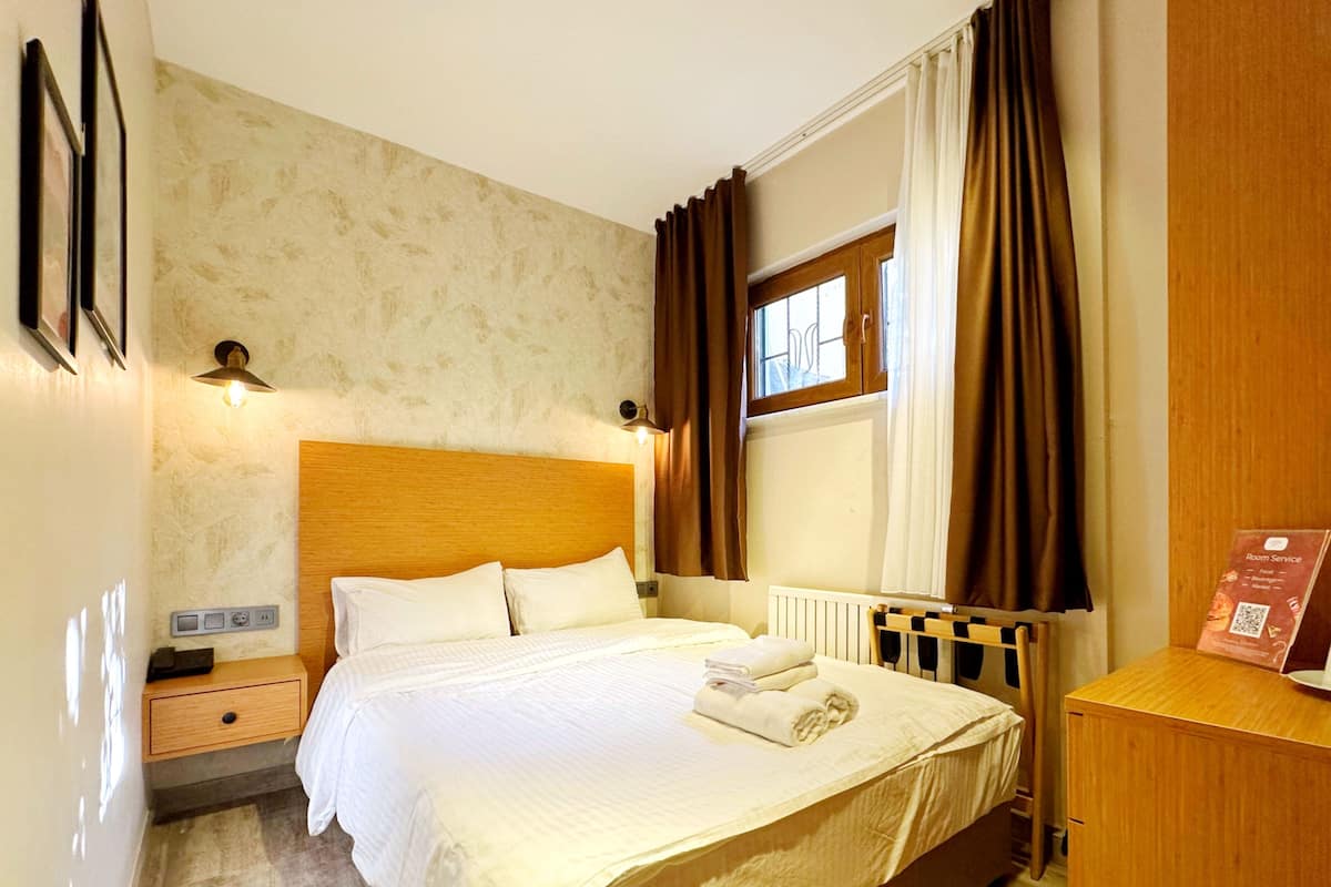 Economy tweepersoonskamer, 1 tweepersoonsbed, niet-roken, privébadkamer | Een minibar met enkele gratis items, een bureau, gratis wifi, beddengoed