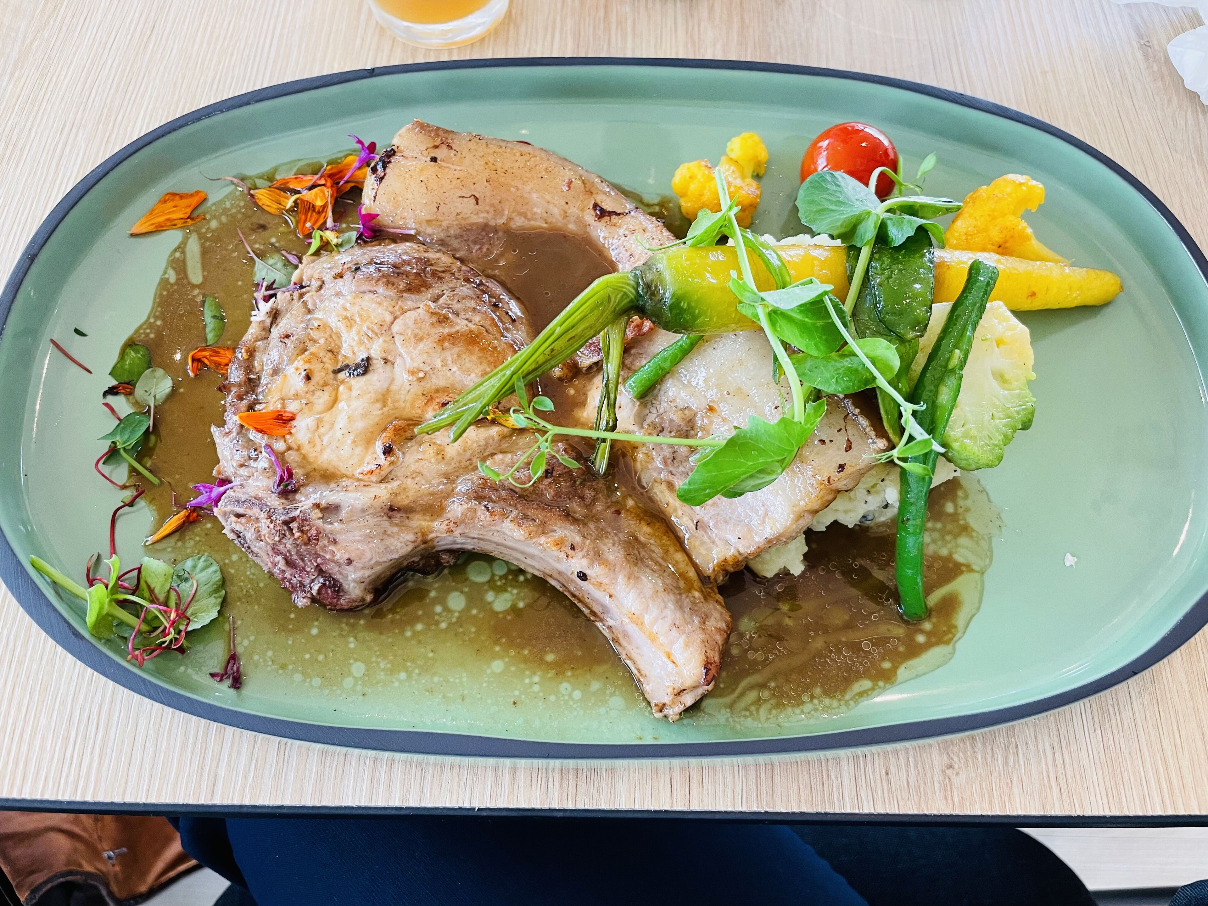 A plate of food with meat, vegetables, and sauce.