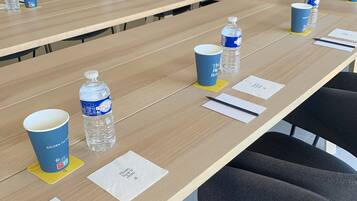 A conference room with a long table, water bottles, and cups.