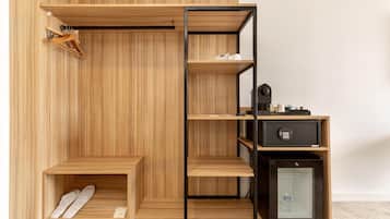 A modern wardrobe with multiple shelves, a hanging rack, and a small safe.