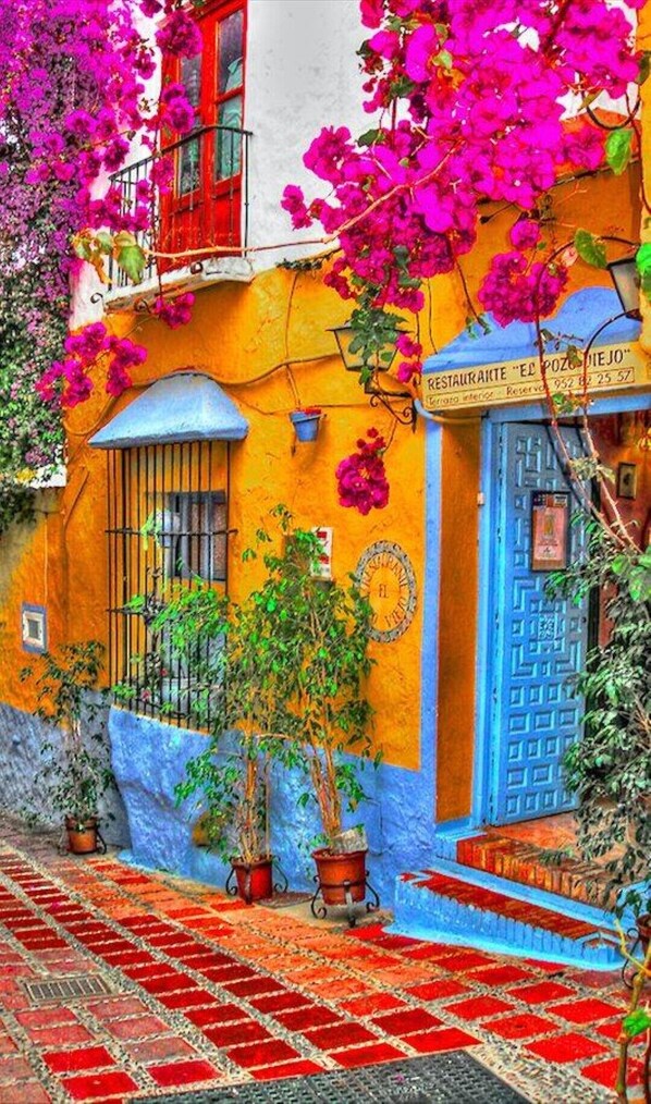 A colorful building with a blue door and a sign that reads "RESTAURANTE EL POZON DEJO".