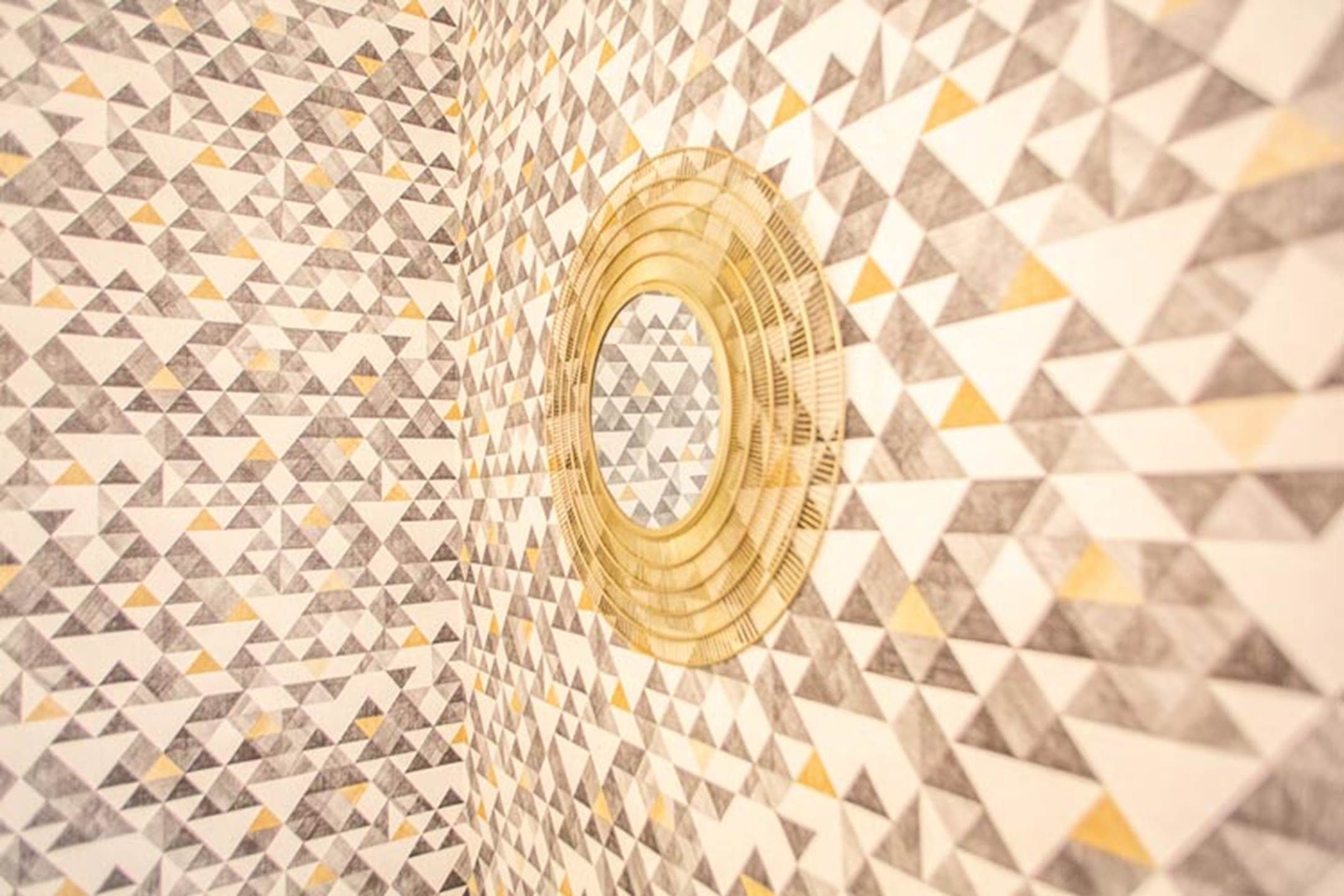 En vägg med ett geometriskt mönster och en cirkelformad design i mitten.