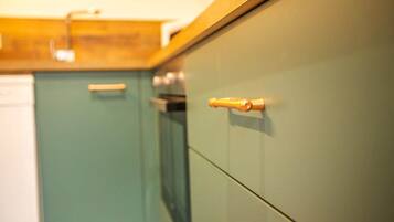 Une cuisine avec des armoires de couleur turquoise et un plan de travail en bois.