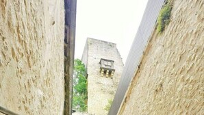 A narrow stone staircase leading to a courtyard with a building in the background.